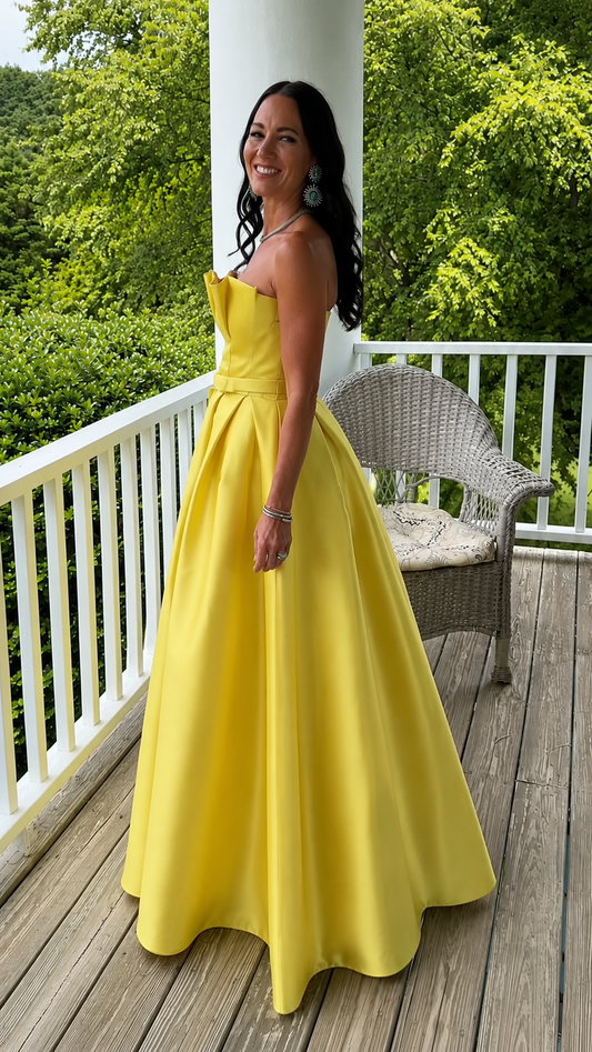 Side view of yellow structured strapless full-length gown