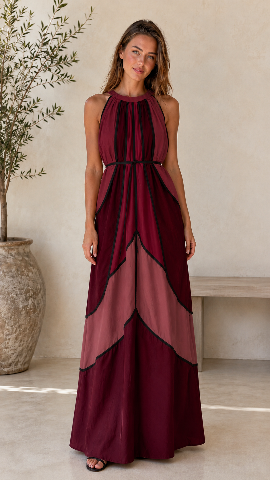 Front view of burgundy halter maxi dress with tonal layered panel effect