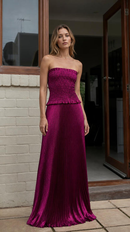 Front view of model wearing magenta strapless pleated two-piece maxi dress