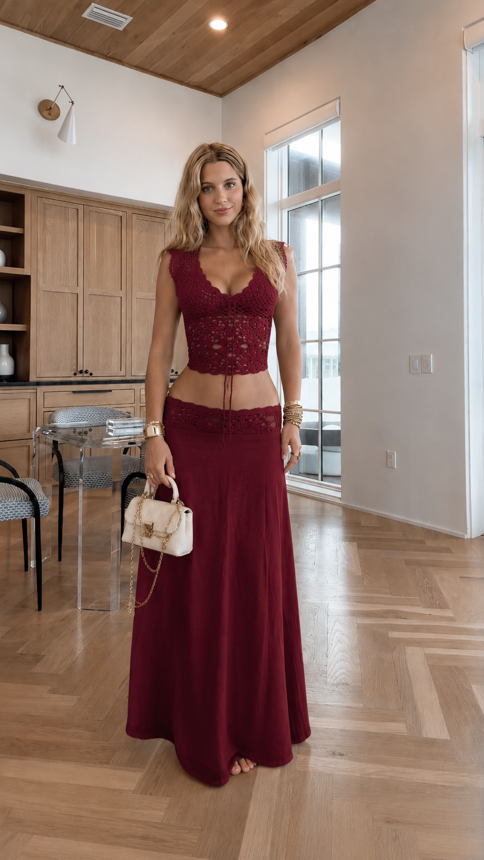 Woman wearing a burgundy crochet lace crop top and matching maxi skirt set