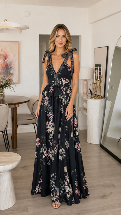Front view of black floral tie shoulder deep V maxi dress with tiered waist detail