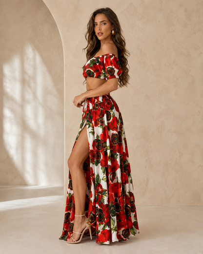 Woman wearing a red floral off shoulder crop top and high slit maxi skirt set front side view
