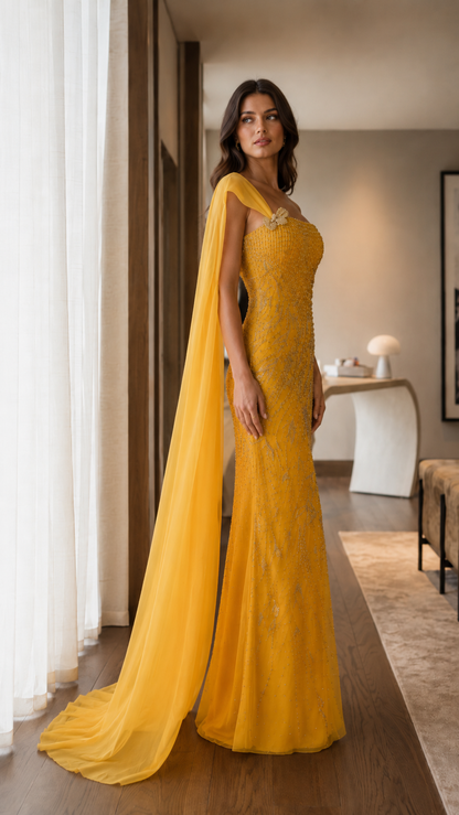 Side angle of marigold embellished one-shoulder formal gown with long cape