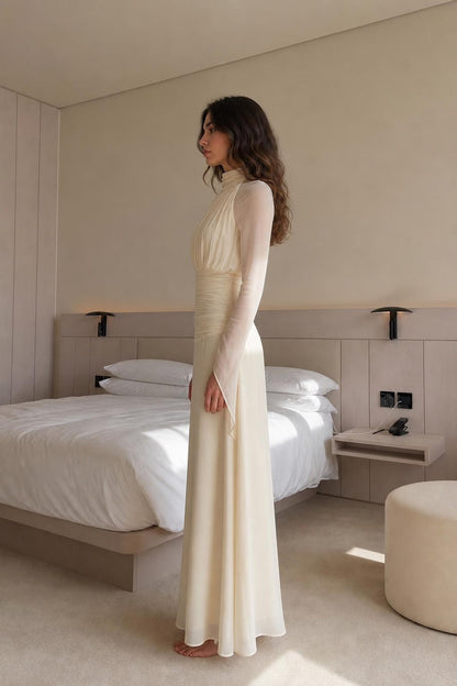 Side profile view of cream maxi dress in bedroom setting