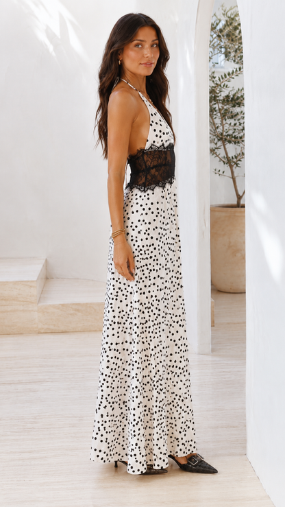 Side view of white polka dot backless halter maxi dress with lace waist