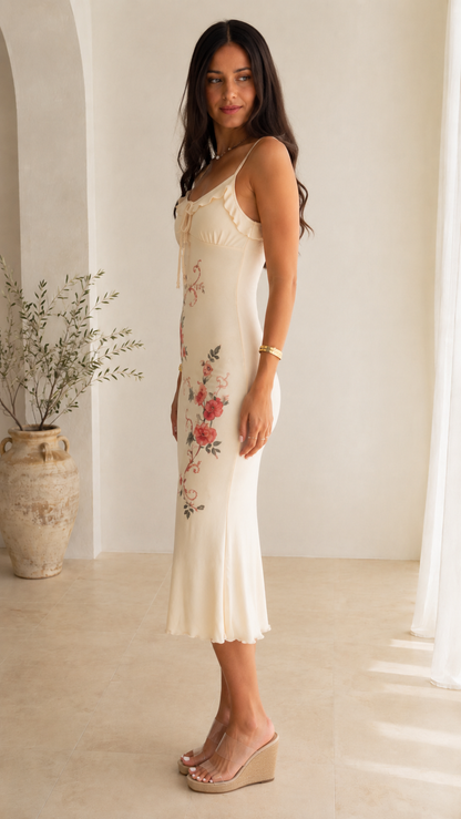 Side view of ivory floral print slip midi dress with slim straps and midi hem