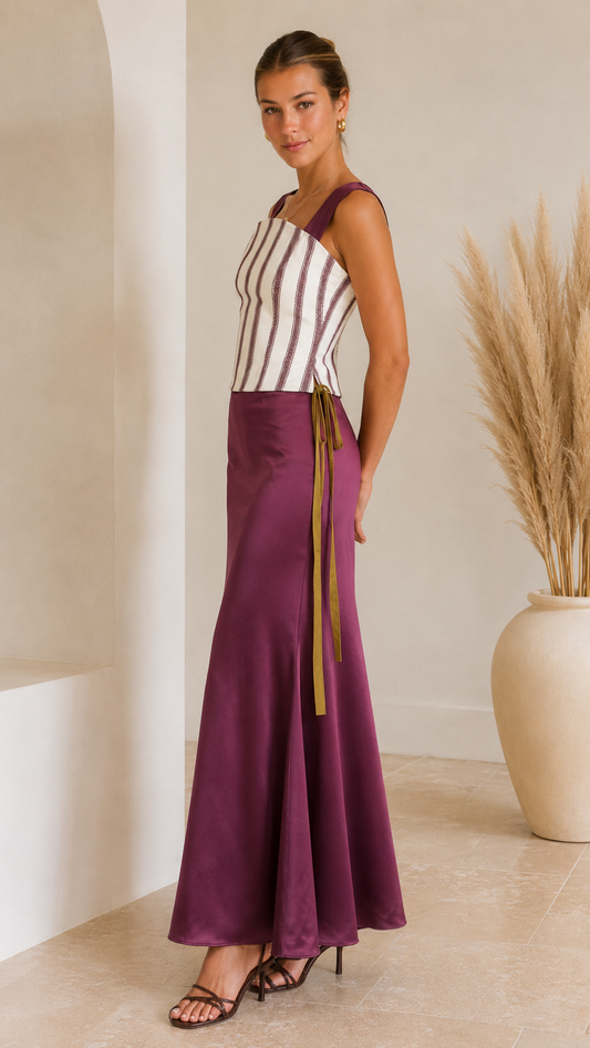 Side view of plum striped corset maxi dress with flared satin-look hem