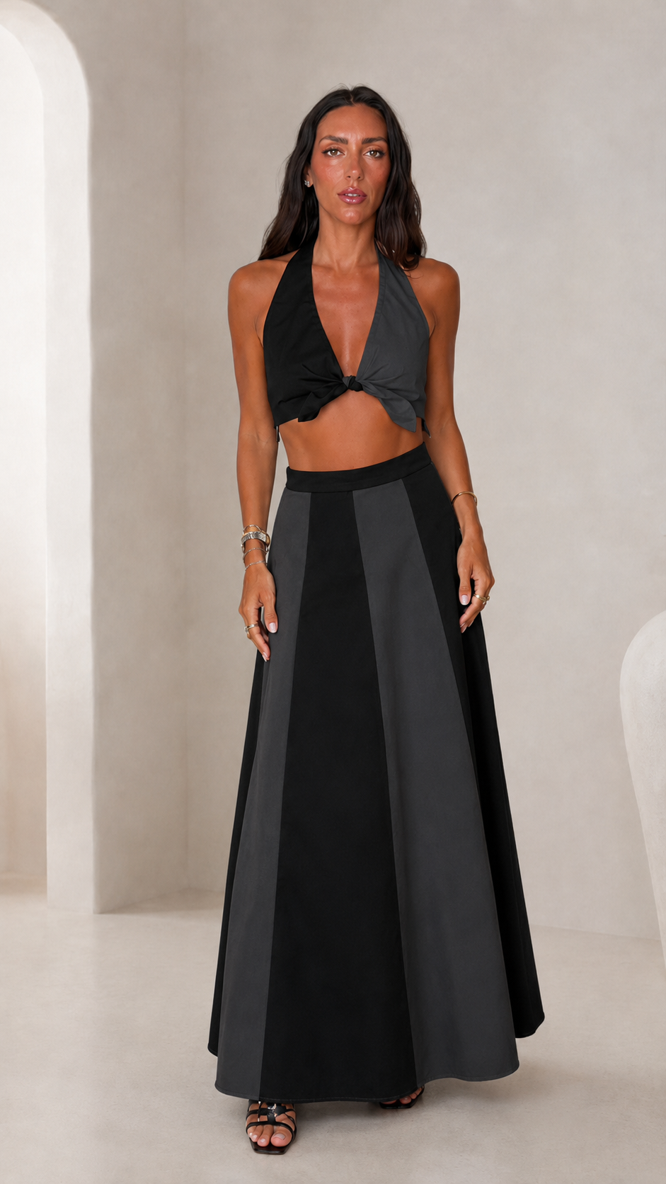 Front view of black and charcoal halter crop top and matching maxi skirt set