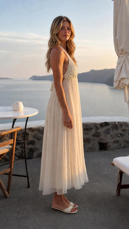 Side profile of woman wearing ivory sequin halter neck maxi dress