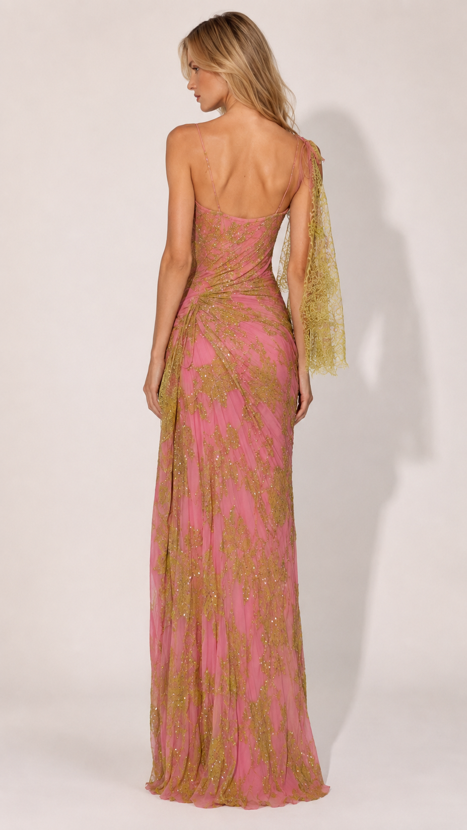 Back view of pink formal gown with low back and sheer shoulder scarf accent