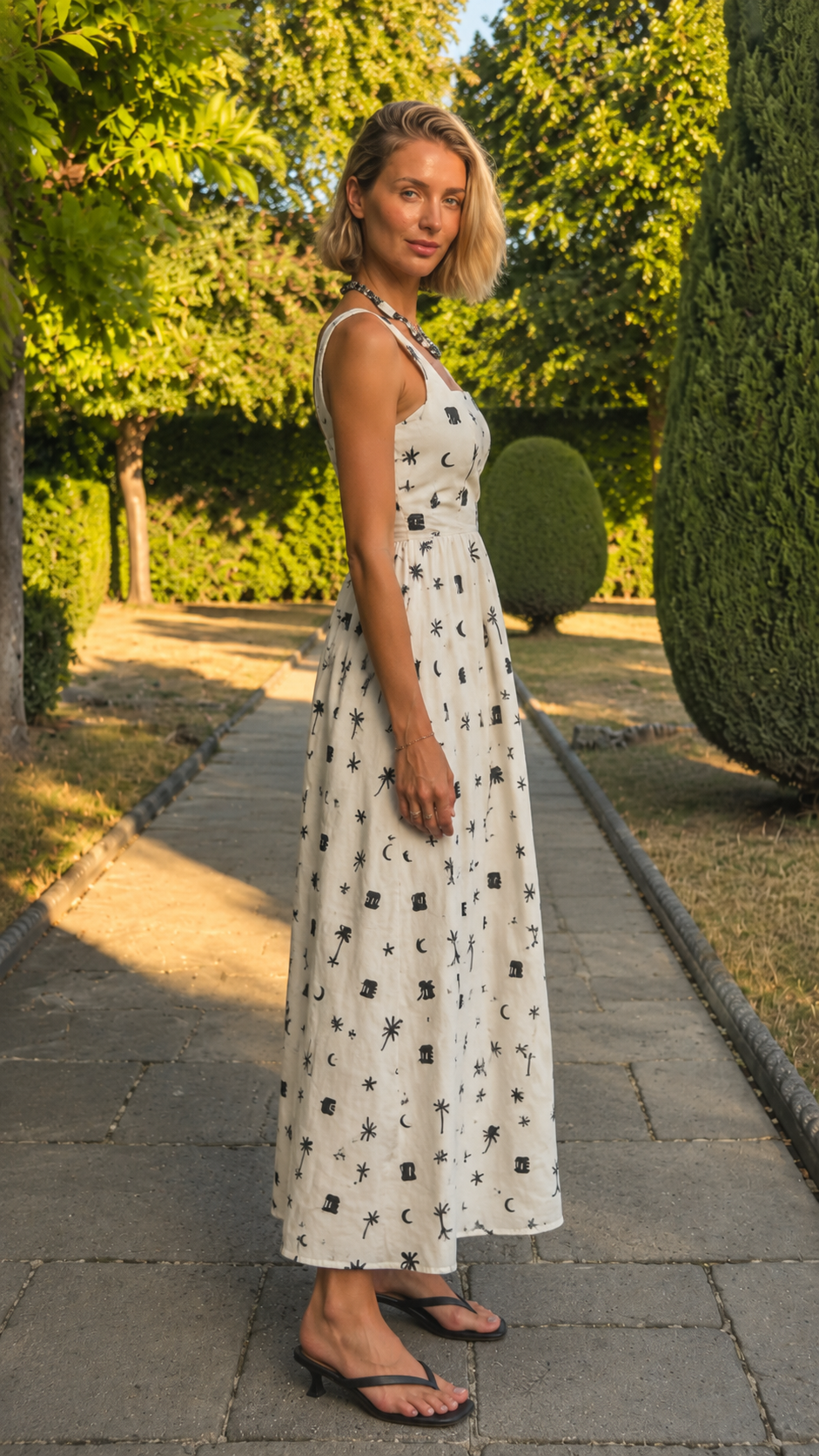 Side view of an ivory printed square neck sleeveless midi dress