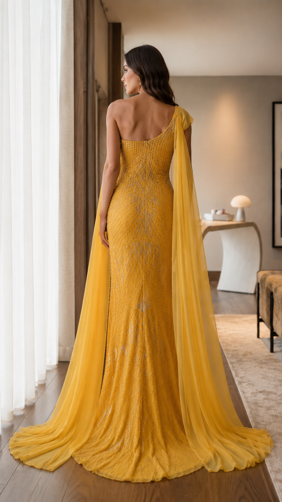 Back view of marigold floor-length mermaid gown with draped shoulder cape