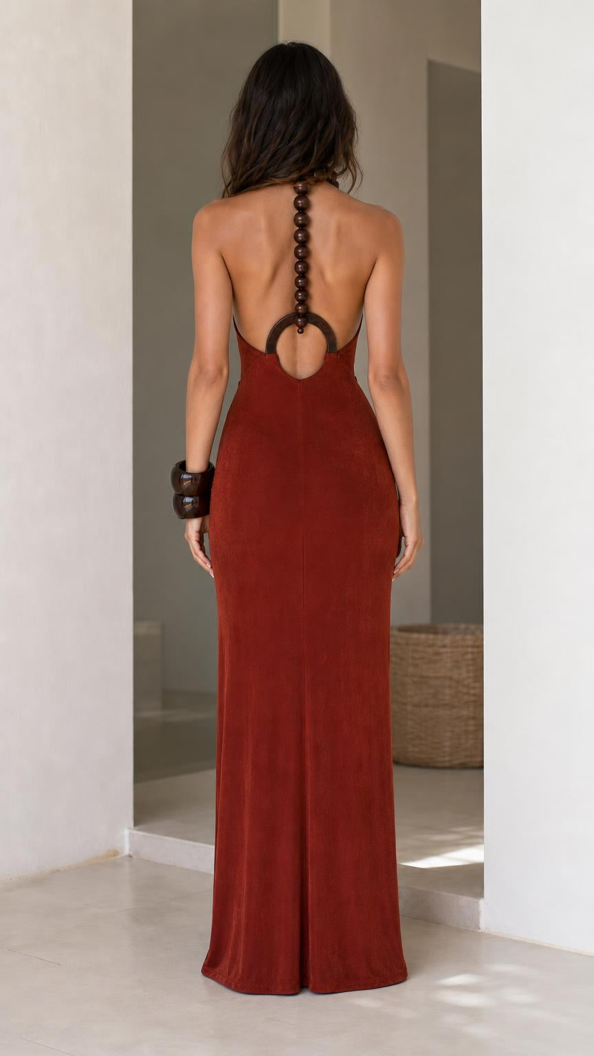 Back view of model in rust open back maxi dress