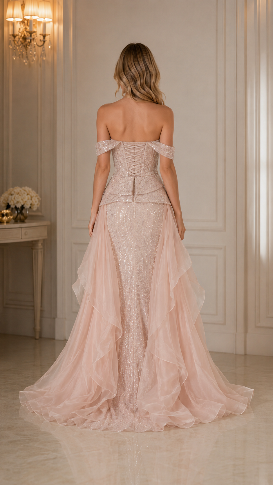 Back view of blush pink fitted evening gown with corset-style back and flowing train