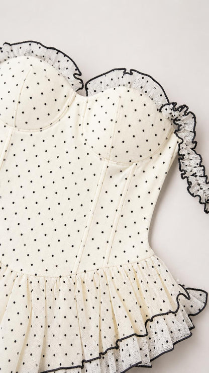 Close-up detail of white polka dot bodice and ruffle trim