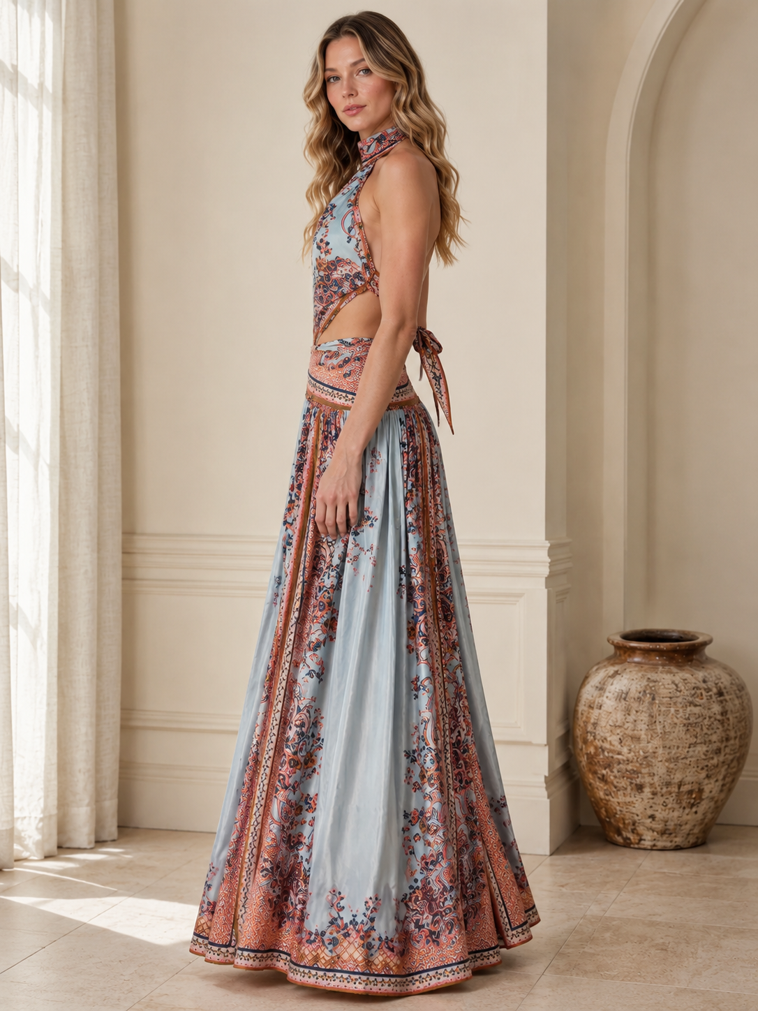 Side view of sky blue printed halter maxi dress showing cutout waist and full skirt