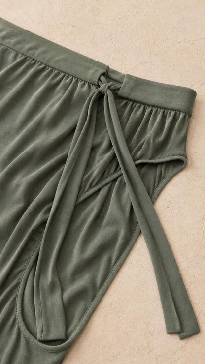 Close-up detail of the waistband and fabric texture of the sage green pants