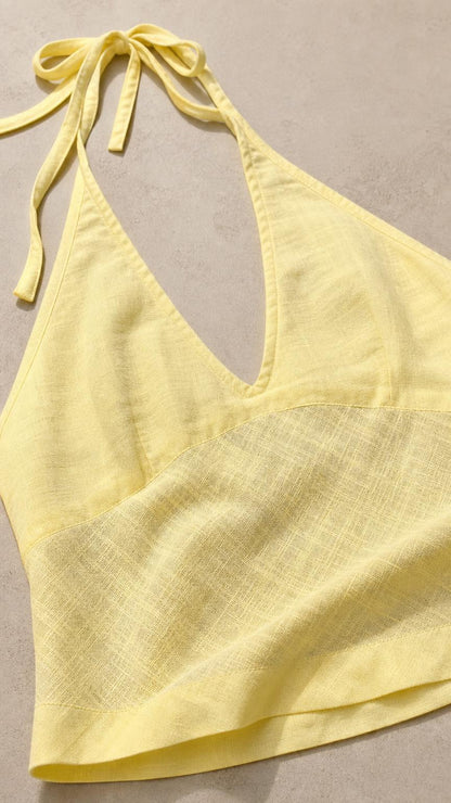 Close-up detail of yellow halter neckline and woven fabric texture