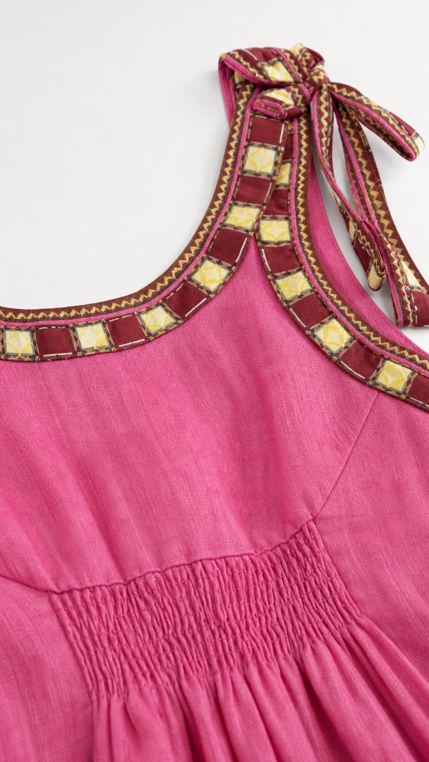 Close-up of pink dress tie straps and smocked bodice detail