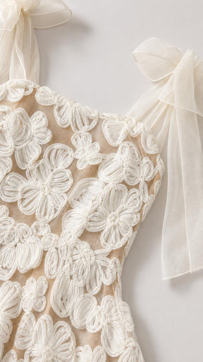 Close-up detail of floral embroidery and shoulder bow