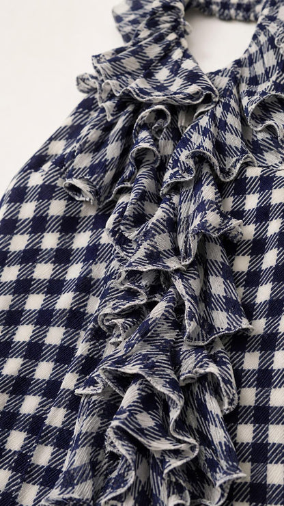 Close-up detail of cascading ruffles on navy gingham fabric