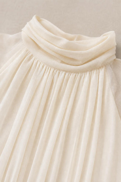 Close-up detail of high mock neckline and chiffon pleating