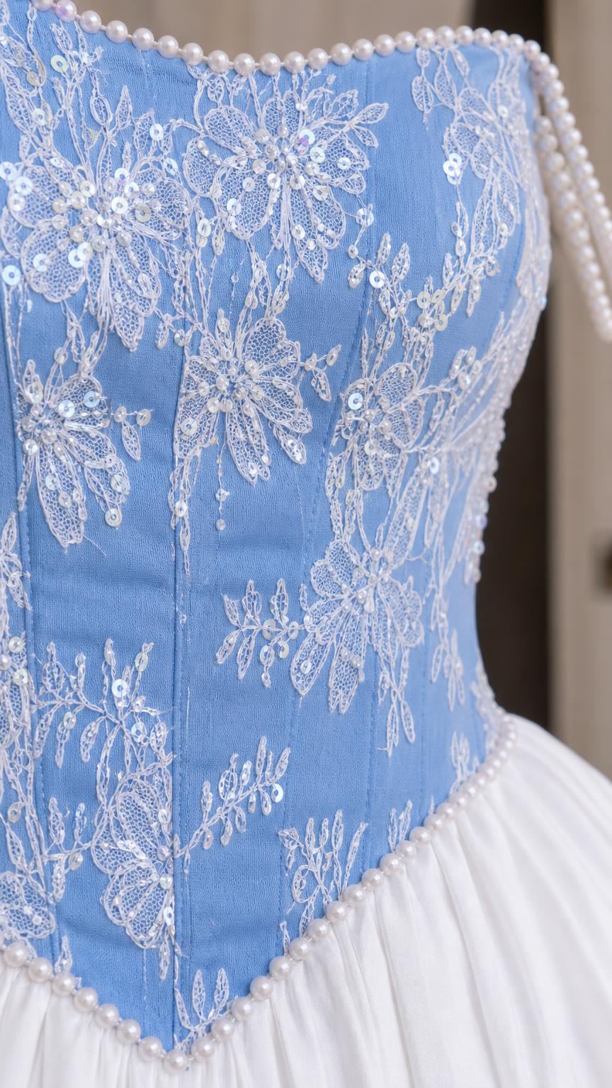 Close-up detail of lace embroidery and pearl trim on bodice