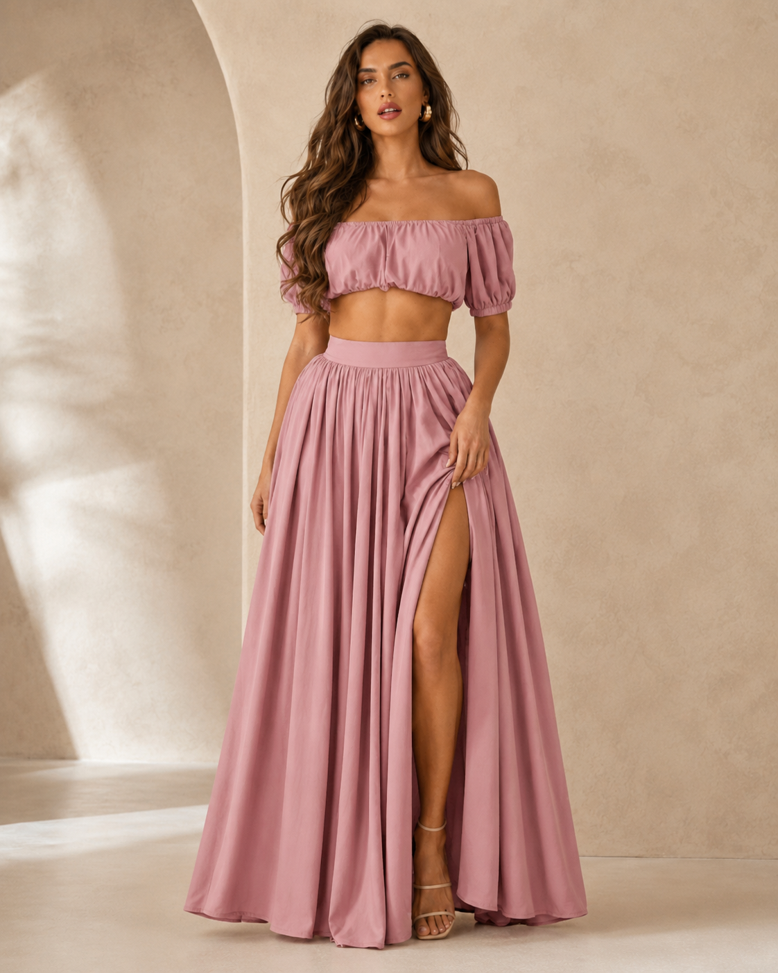 Woman wearing a dusty rose off shoulder crop top and high slit maxi skirt set front view