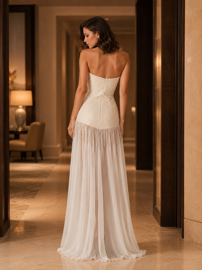 Back view of ivory strapless evening dress showing fitted bodice and flowing chiffon-like skirt