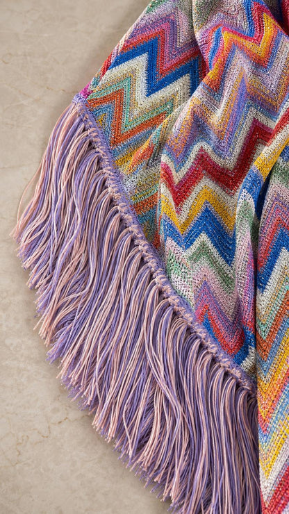 Close-up of textured chevron knit fabric and purple fringe trim