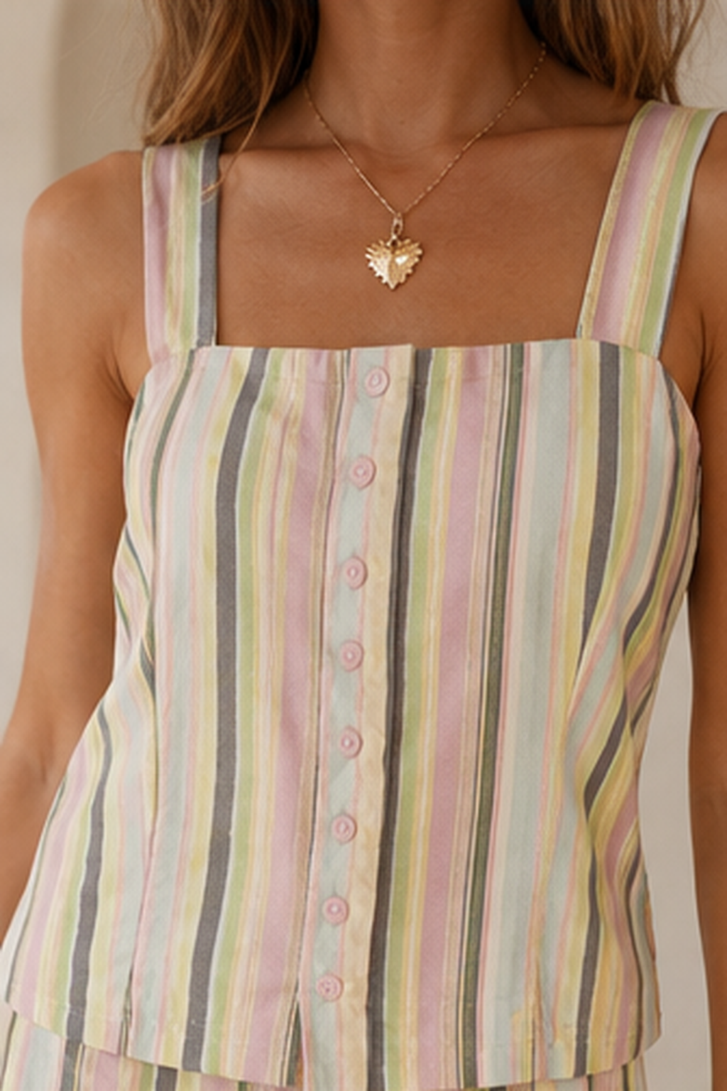 Close-up of square neckline and button-front detail on pastel striped sleeveless top