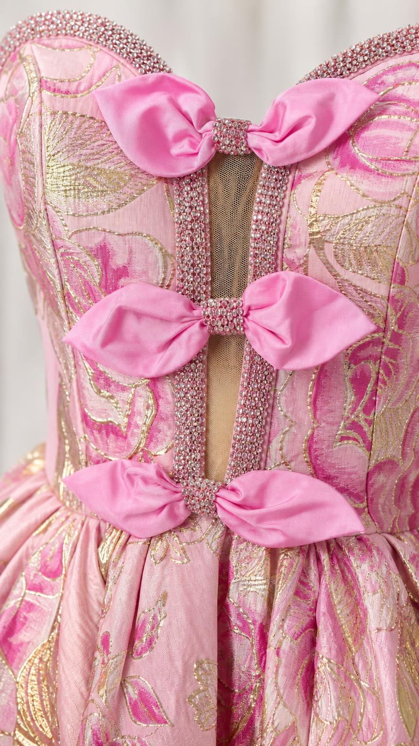 Close-up detail of rhinestone trim and pink bows on dress bodice
