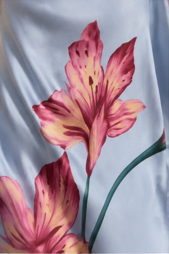 Close-up of pink floral print on light blue smooth fabric
