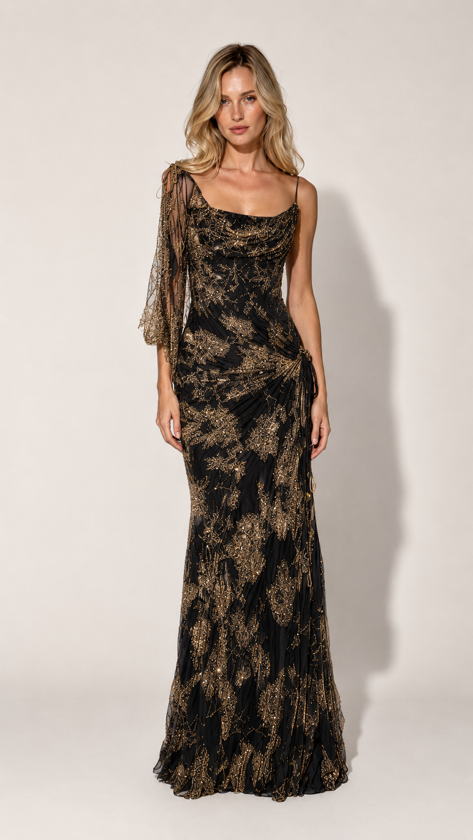 Front view of black one-shoulder shimmering maxi gown with sheer cape sleeve