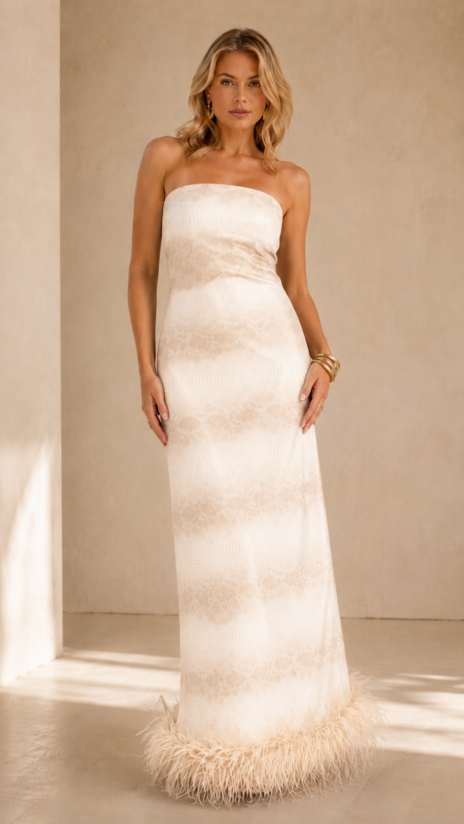 Front view of ivory strapless maxi dress with tonal shading and feather-trim hem
