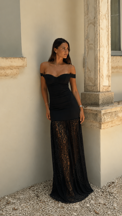 Front view of black off-shoulder ruched maxi dress with sheer lace-look floor-length skirt