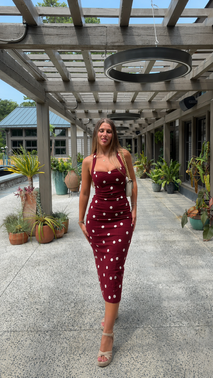 Front view of burgundy polka dot fitted midi dress