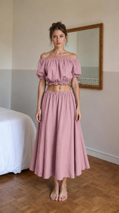 Front view of woman wearing pink off-shoulder crop top and midi skirt set