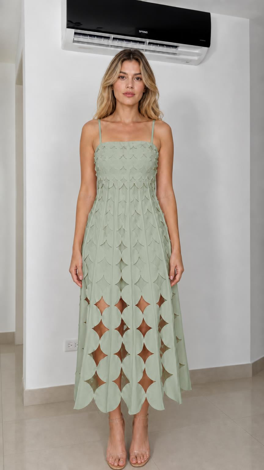 Front view of model wearing sage green laser-cut geometric midi dress