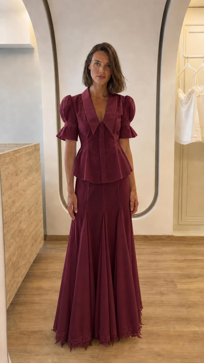 Front view of woman in burgundy two-piece peplum top and maxi skirt set