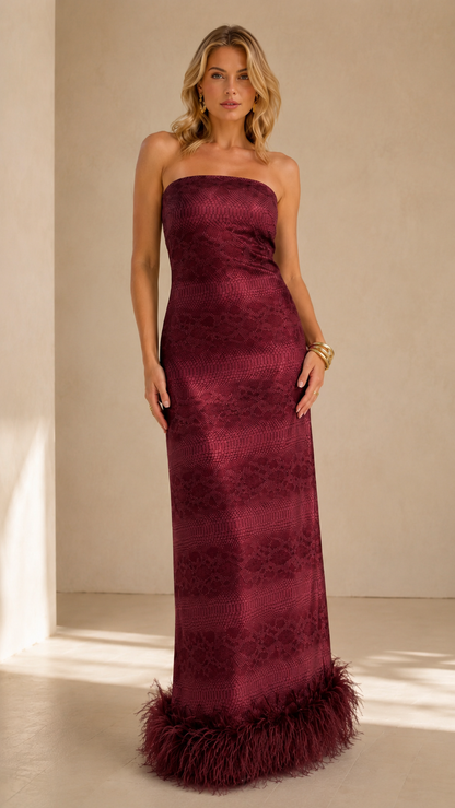 Front view of burgundy strapless evening maxi dress with feather-trim hem