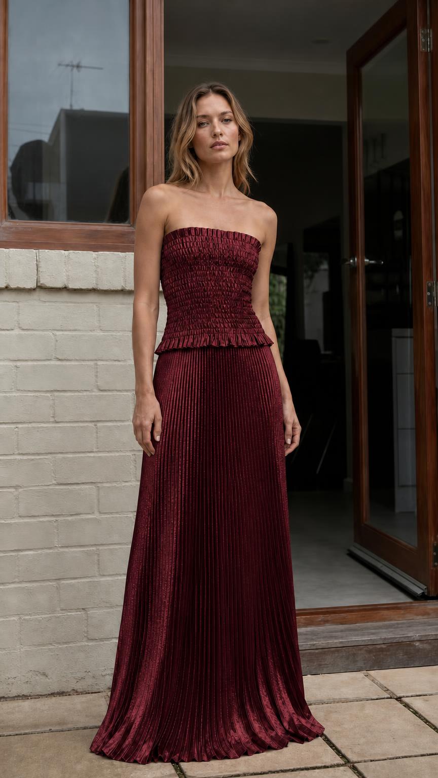 Model wearing burgundy strapless pleated two-piece maxi dress