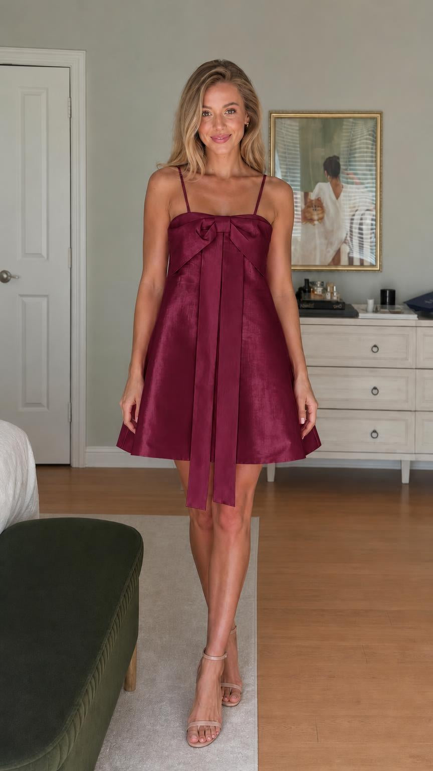 Model wearing burgundy satin bow-front mini dress