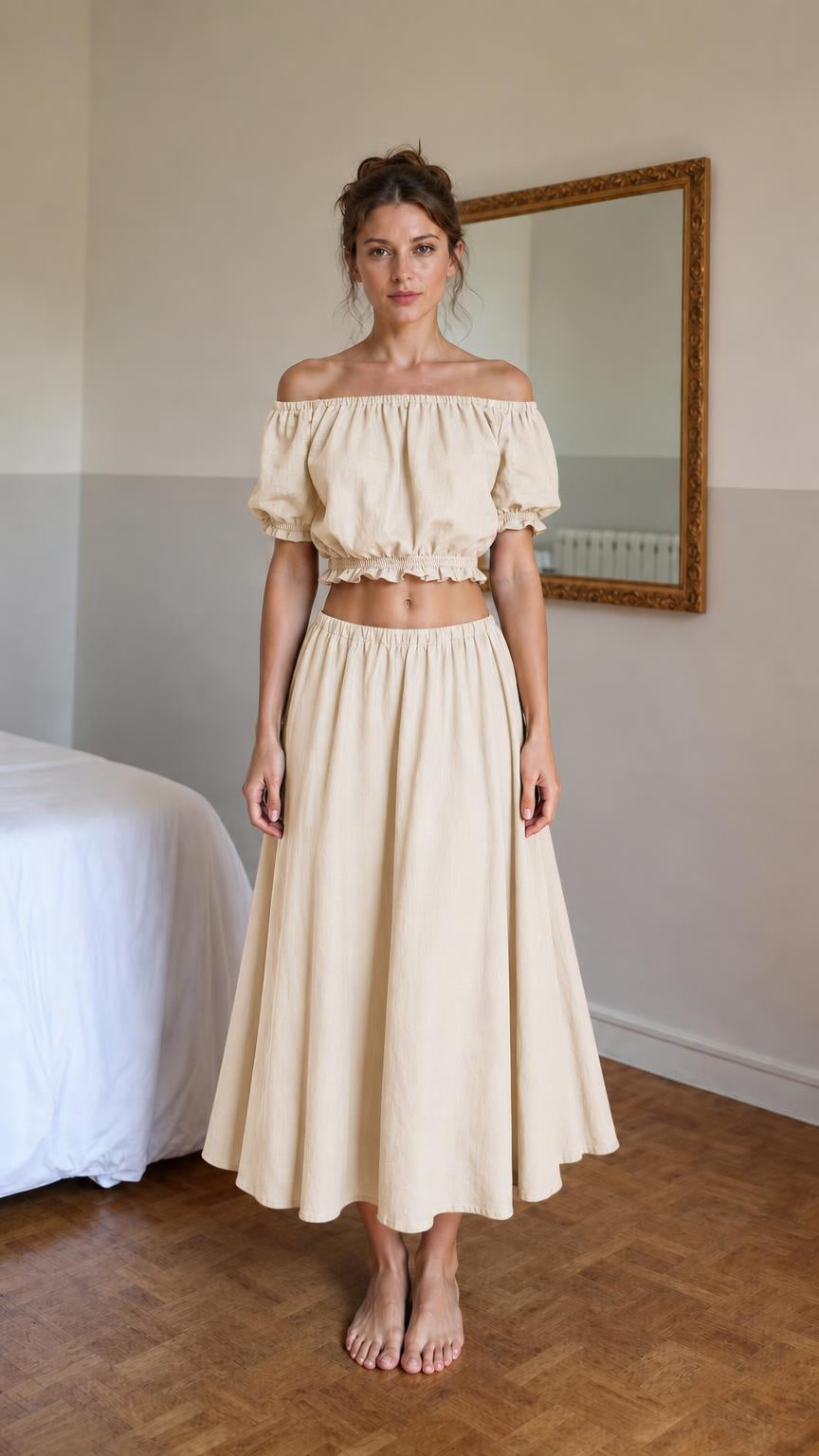 Front view of woman wearing beige off-shoulder crop top and midi skirt set